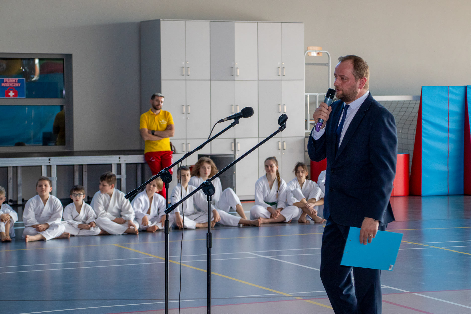 Na zdjęciu widoczny dyrektor GOSTiR podczas przemowy oraz grupa dzieci z zajęć karate wraz z instruktorem